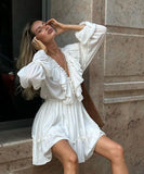 Elegant V-Neck White Dress with Flared Sleeves and Ruffled Details